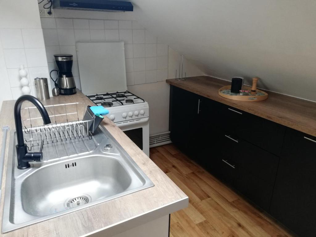 a kitchen with a sink and a stove at La Plage in Fécamp