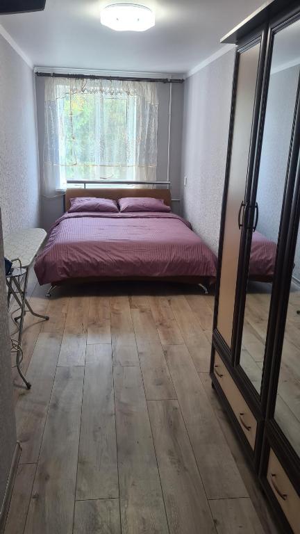 um quarto com uma cama, uma janela e um espelho em 2-х кімнатна квартира студія у центрі Миргорода em Myrhorod