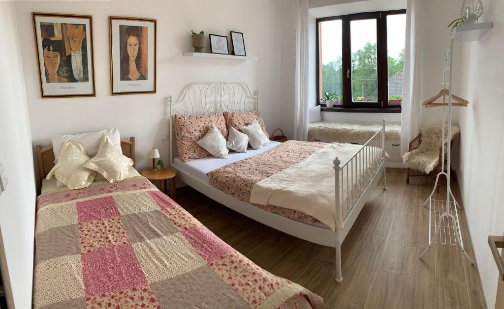 a bedroom with a white bed and a bed sidx sidx sidx sidx at Tři okna do hor in Malá Štáhle