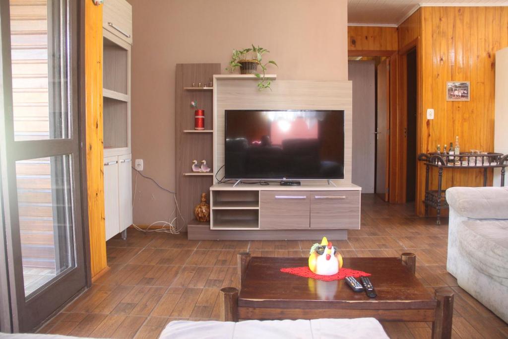 uma sala de estar com uma televisão e uma mesa em Chalé na Serra Gaúcha, em Picada Café!! em Picada Cafe