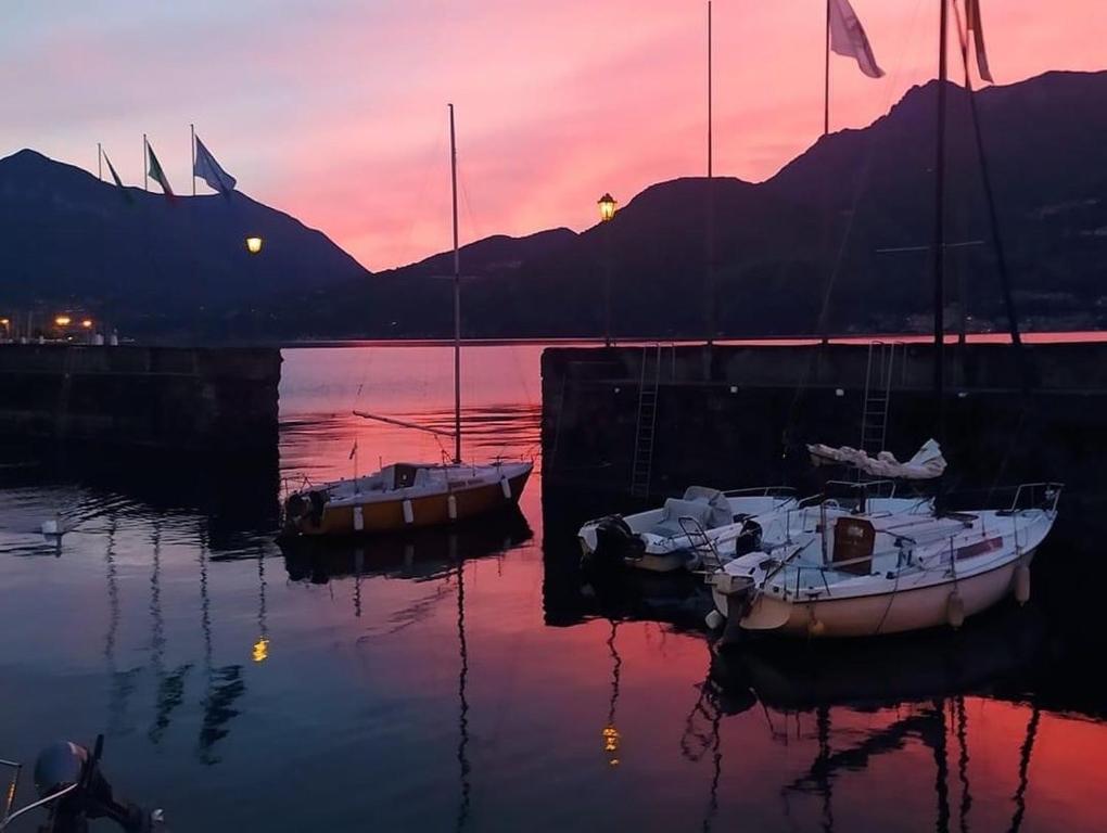 dwie łodzie zacumowane w wodzie o zachodzie słońca w obiekcie Il porticciolo w mieście Bellano