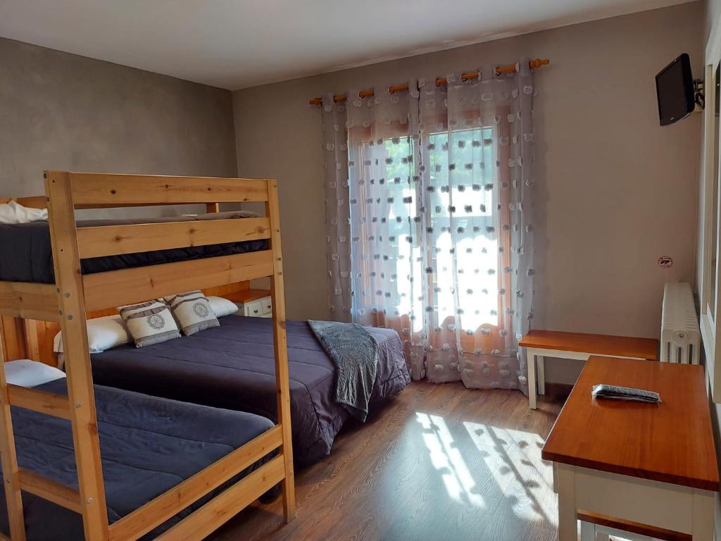 a bedroom with a bunk bed and a desk at Hotel Casa Morlans in Panticosa