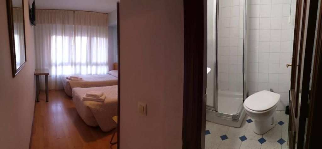 Un pequeño baño con inodoro y ducha. en Hospedaje Covadonga, en Gijón