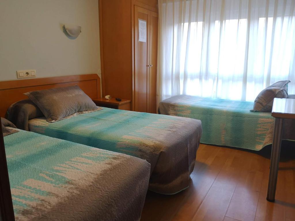 Ліжко або ліжка в номері Hospedaje Covadonga