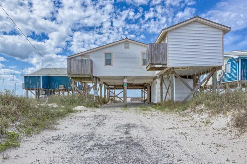 ein Haus am Strand mit einer Veranda in der Unterkunft Dorsey's Wave On by Meyer Vacation Rentals in Fort Morgan