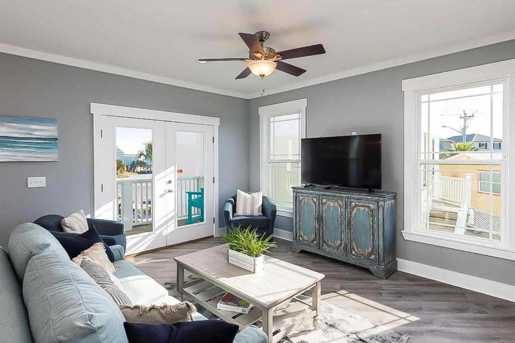 a living room with a couch and a flat screen tv at Carried Away by Meyer Vacation Rentals in Gulf Shores