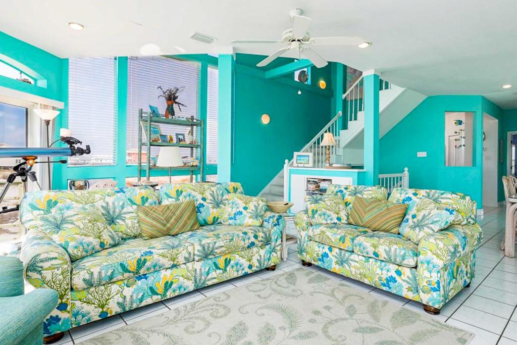 ein Wohnzimmer mit 2 Sofas und einer Treppe in der Unterkunft Dolphin View by Meyer Vacation Rentals in Gulf Shores