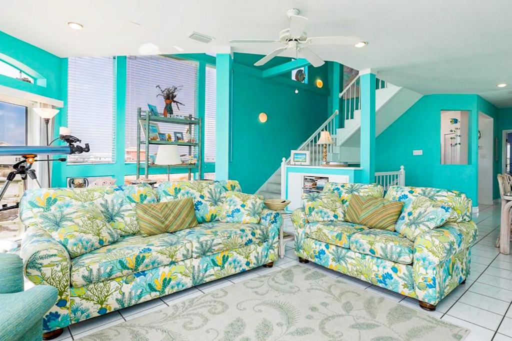 een woonkamer met twee banken en een trap bij Dolphin View by Meyer Vacation Rentals in Gulf Shores