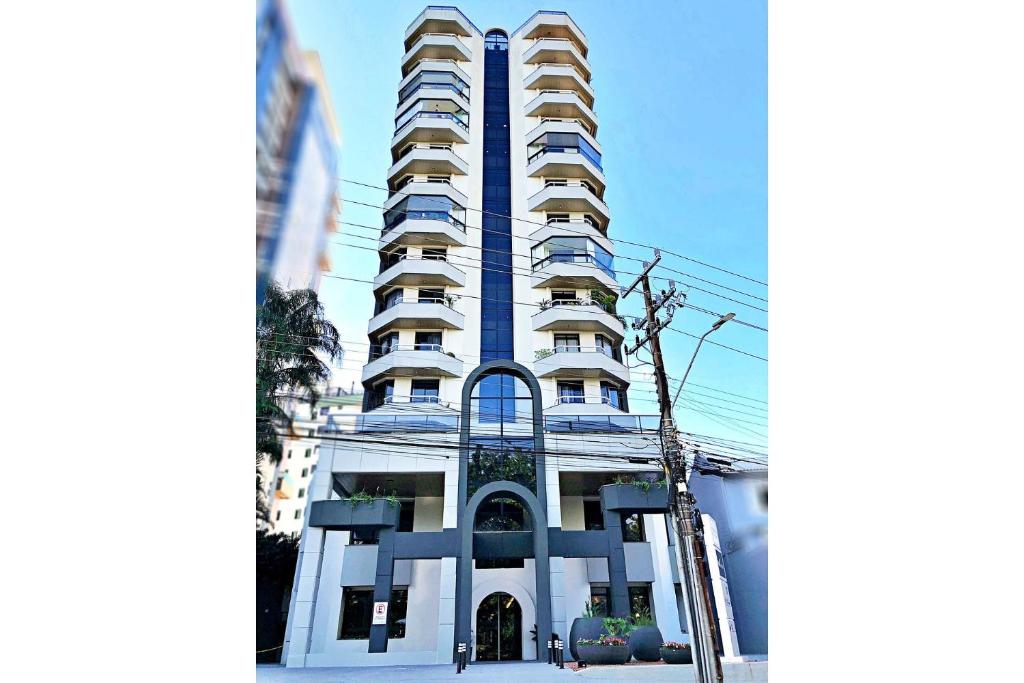 a tall white building in front of a building at Central Park Flat Residence - Home Time in Florianópolis