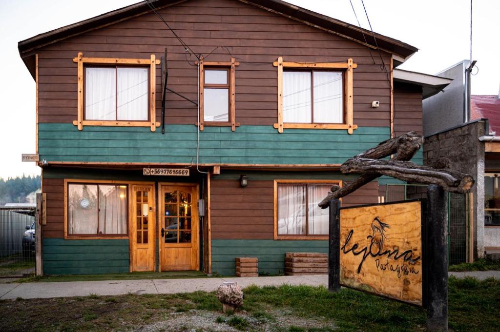 a house with a green and wooden at Hostal Lejana Patagonia in Cochrane