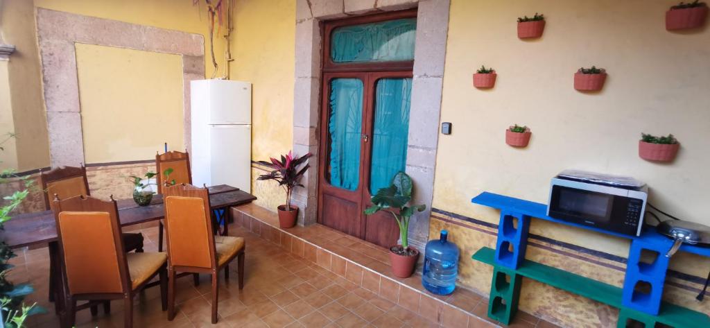 cocina con mesa, sillas y nevera en Lele y Panchito en el Centro, en Querétaro