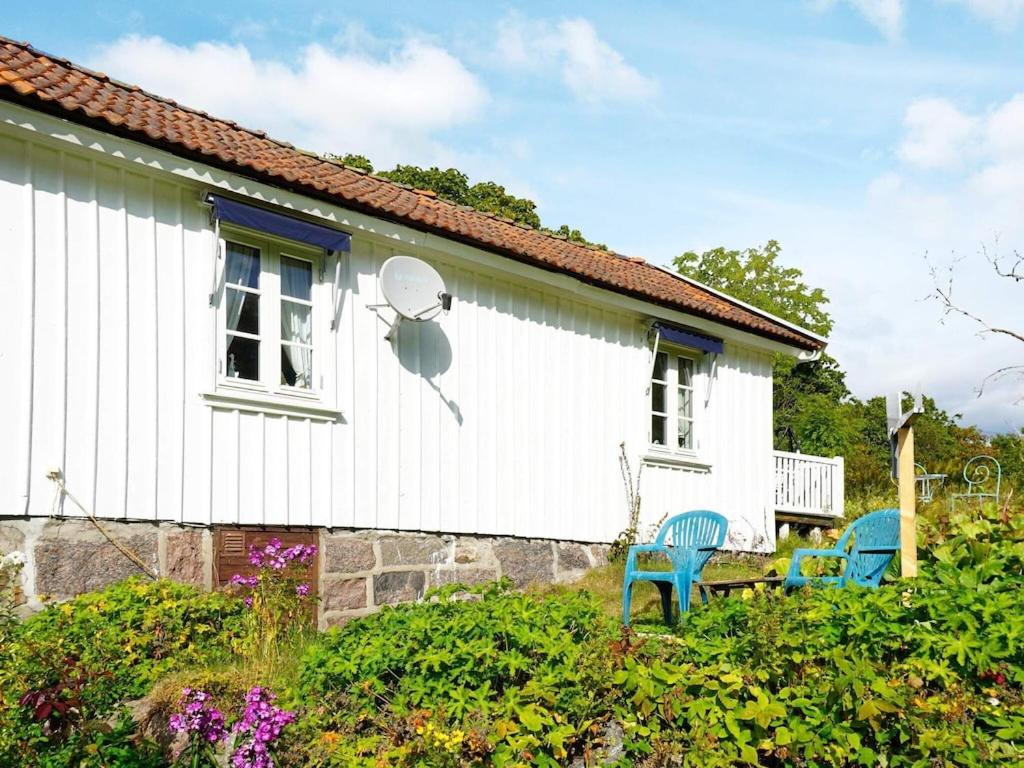 Uma casa branca com um satélite ao lado. em 5 person holiday home in FISKEB CKSKIL em Fiskebäckskil