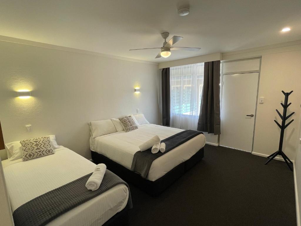a hotel room with two beds and a ceiling fan at Royal Hotel Motel Scone in Scone