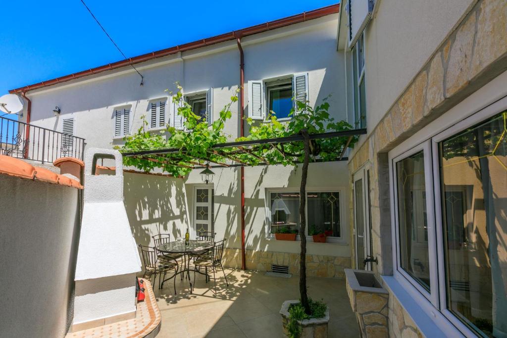 a building with a patio with a table and chairs at House RUZICA in Novi Vinodolski