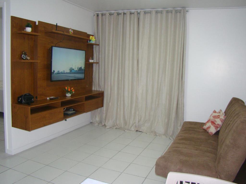 - un salon avec un canapé et une télévision dans l'établissement APT TOP BEIRA MAR NEO 2.0, à Maceió