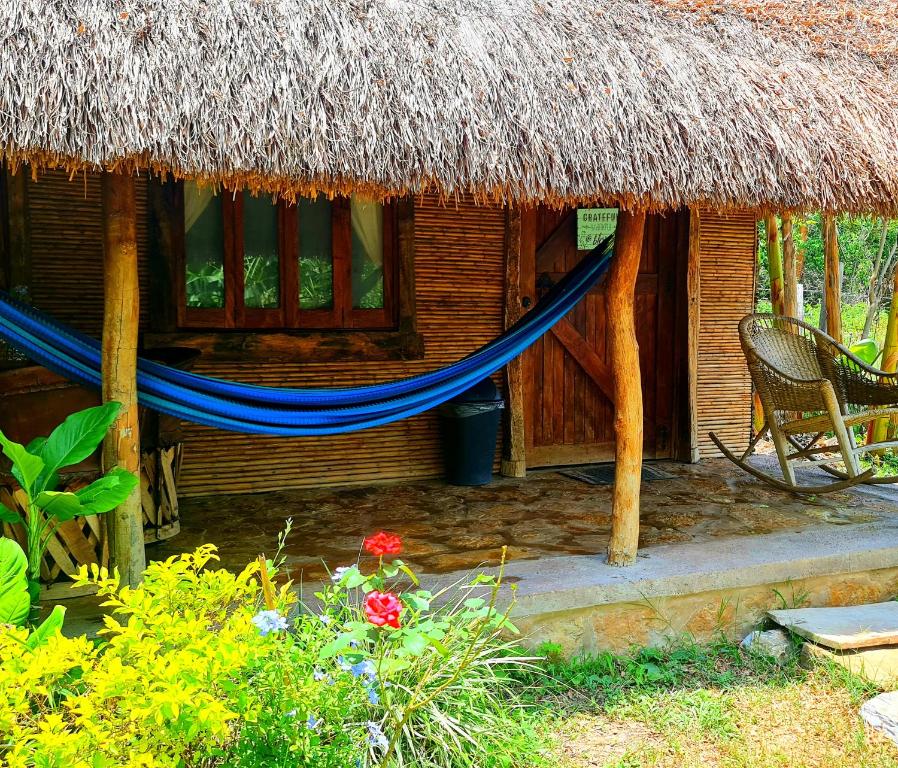 a house with a blue hammock in front of it at Cabañas Mannan in Tanchachín