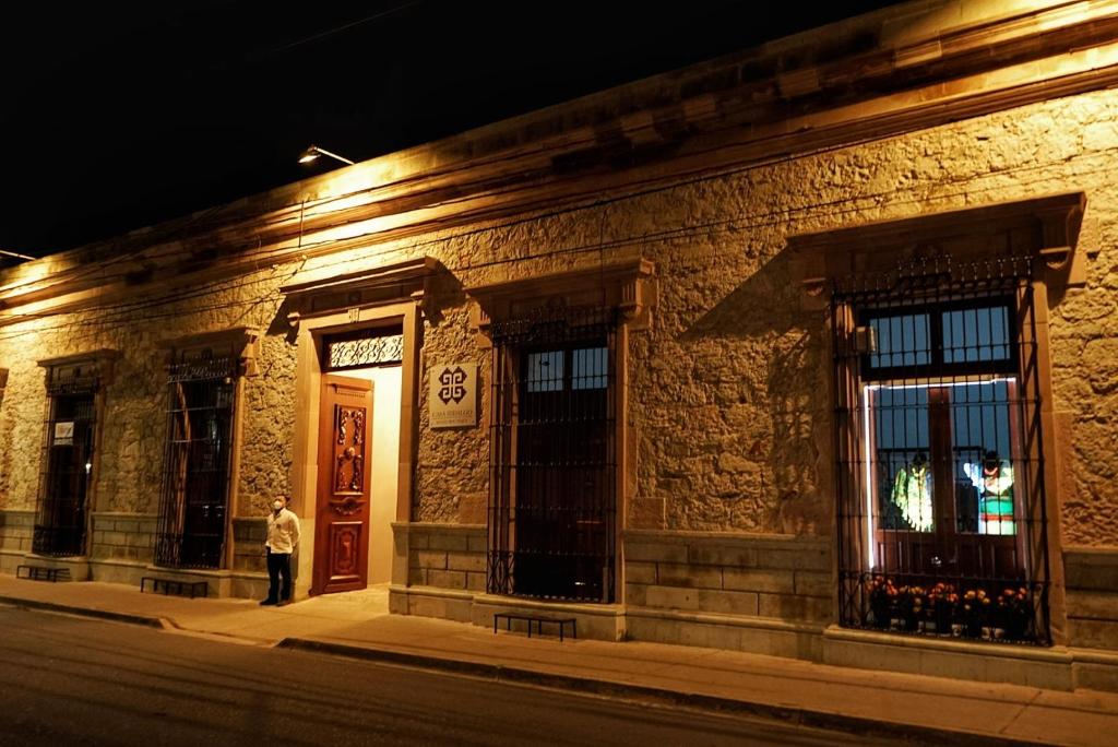 a man standing in front of a building at night at Casa Hidalgo Hotel Boutique in Oaxaca City