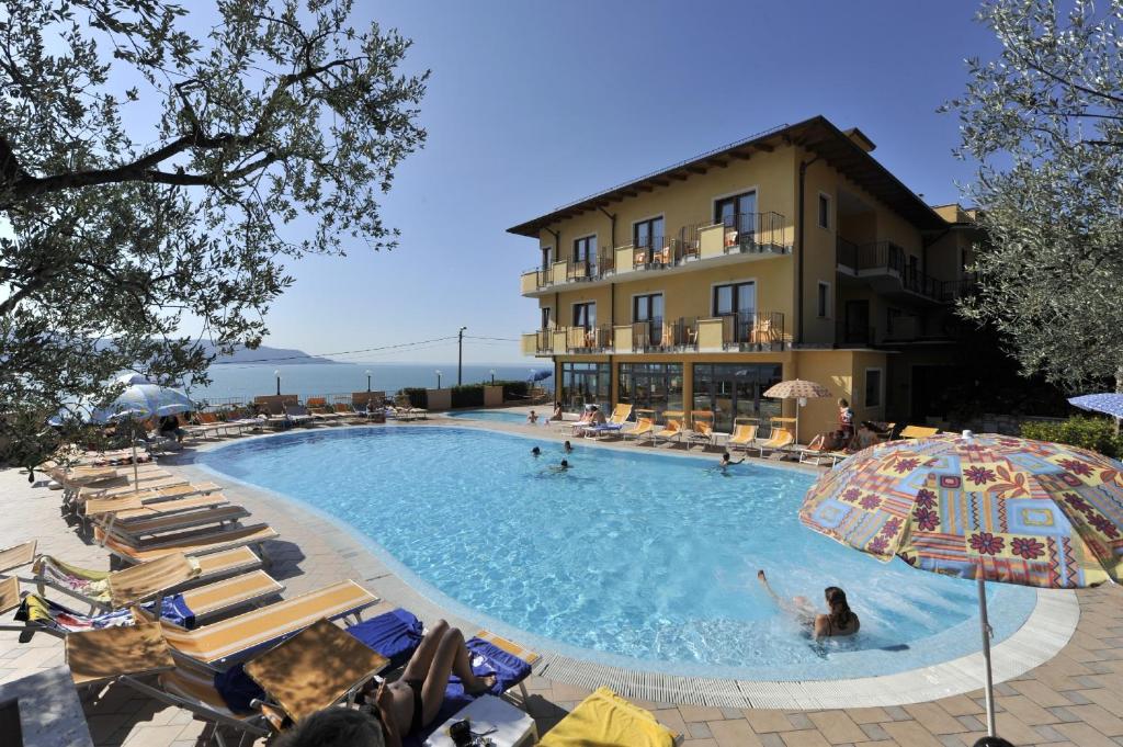 a large swimming pool with people in a hotel at All Inclusive Hotel Piccolo Paradiso in Toscolano Maderno