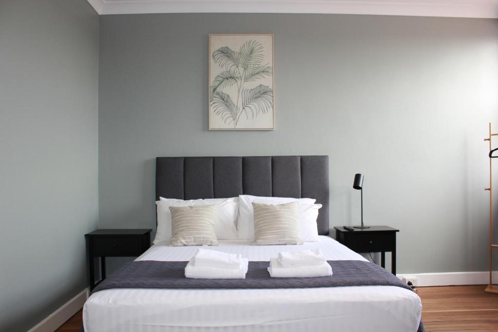 - une chambre avec un grand lit et des oreillers blancs dans l'établissement Colliery Inn Wallsend, à Newcastle