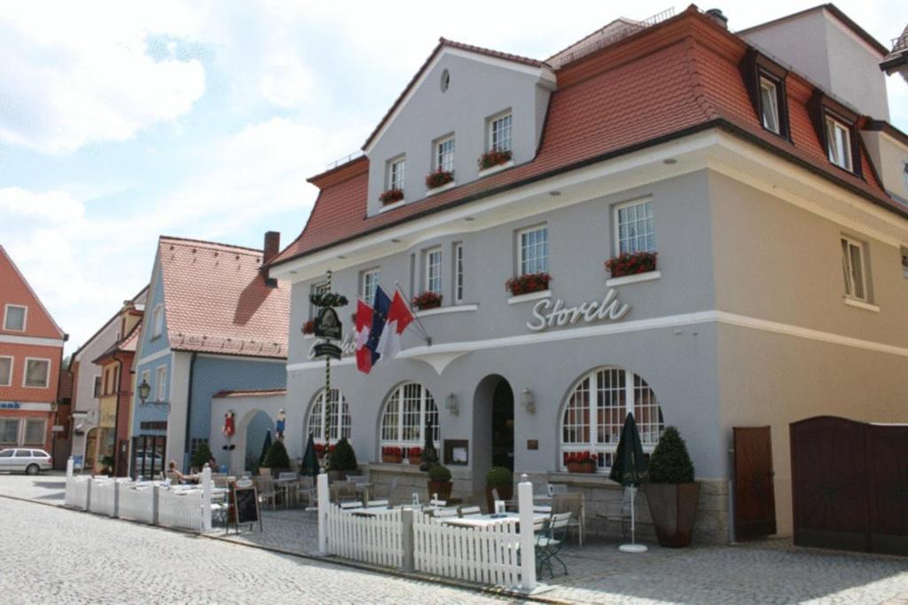 a large white building with a red roof at Hotel Gasthof Zum Storch in Schlüsselfeld