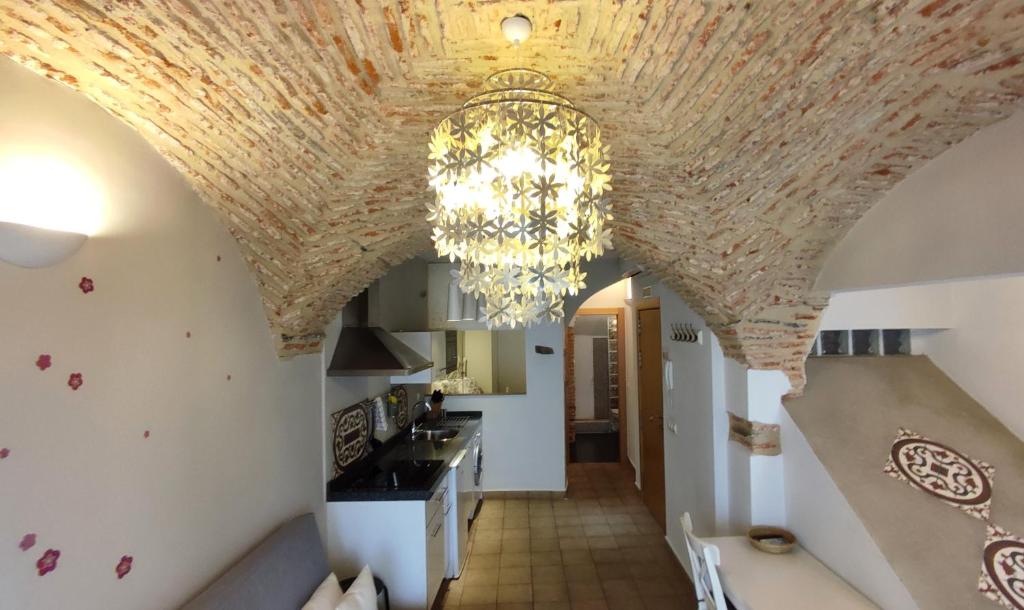 a kitchen with a chandelier hanging from a ceiling at Apartamentos Turísticos ENCANTO in Cáceres