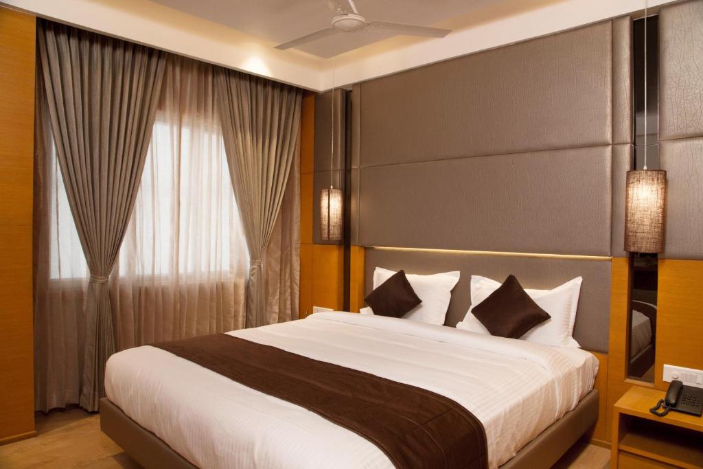 a bedroom with a large bed and a window at Sri Aadhish Grand Hotel in Arantāngi