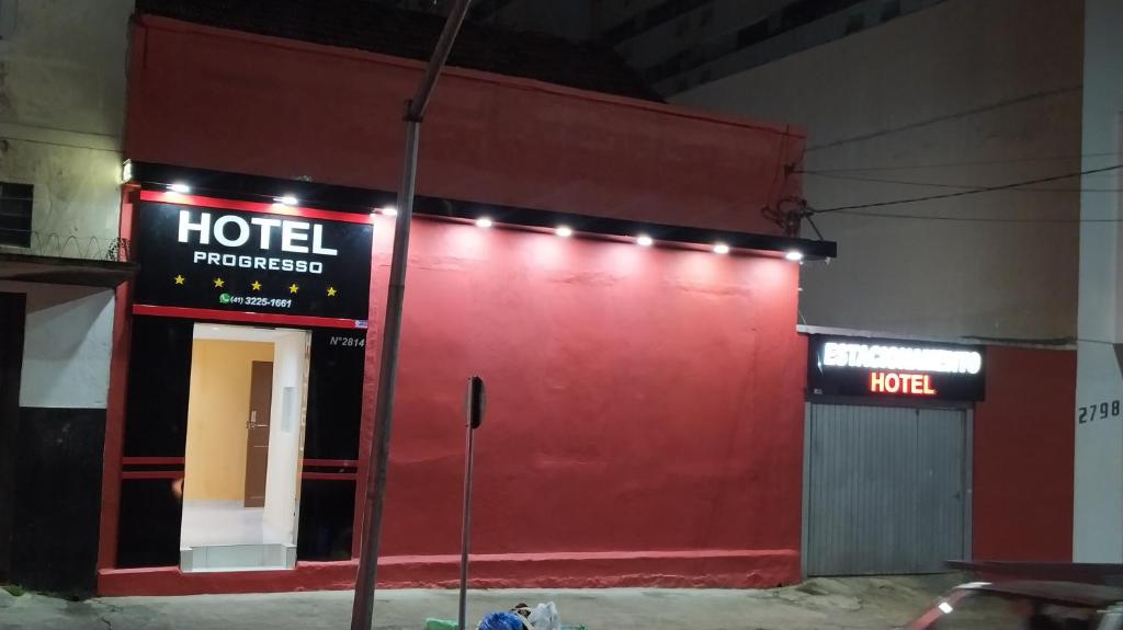 a red wall of a hotel with lights on it at Hotel Progresso in Curitiba