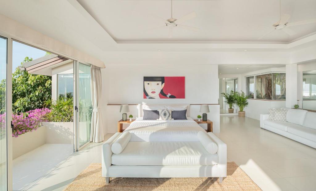 a white bedroom with a white bed and a couch at Baan Bon Khao - Seaview Private Villa in Choeng Mon Beach