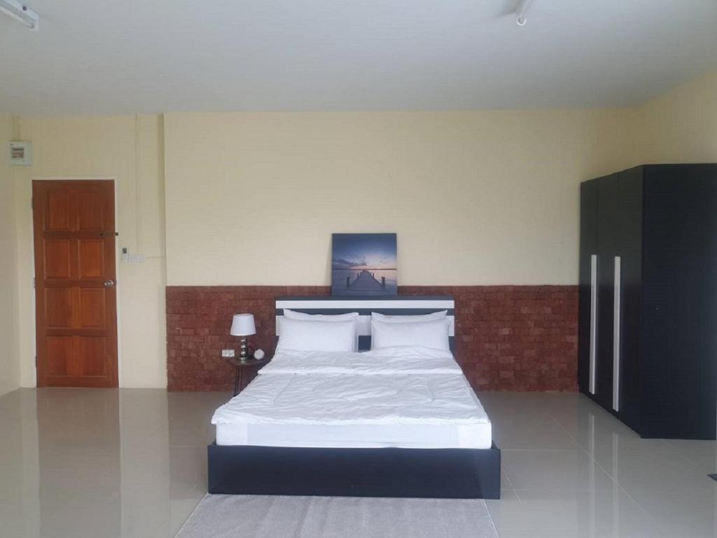 1 dormitorio con 1 cama grande con sábanas blancas en Ek Residence Banchang City en Ban Chang