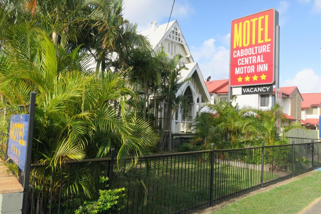 a house with a motel sign in front of a fence at Caboolture Central Motor Inn, Sure Stay Collection by BW in Caboolture