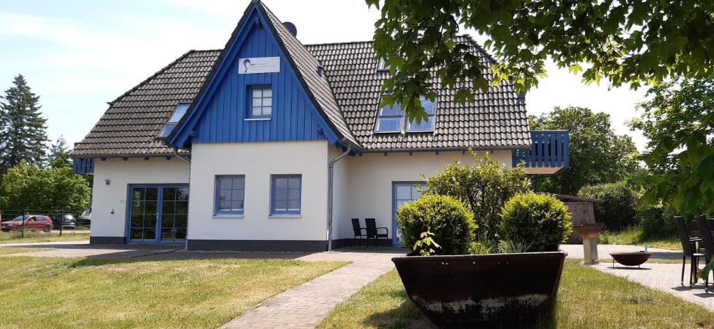 ein blau-weißes Haus mit einem Dach in der Unterkunft Ferienwohnung Alter Fischerhof in Malchow