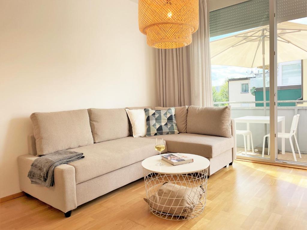 ein Wohnzimmer mit einem Sofa und einem Tisch in der Unterkunft Holiday Suites Sankt Martin in Klagenfurt am Wörthersee