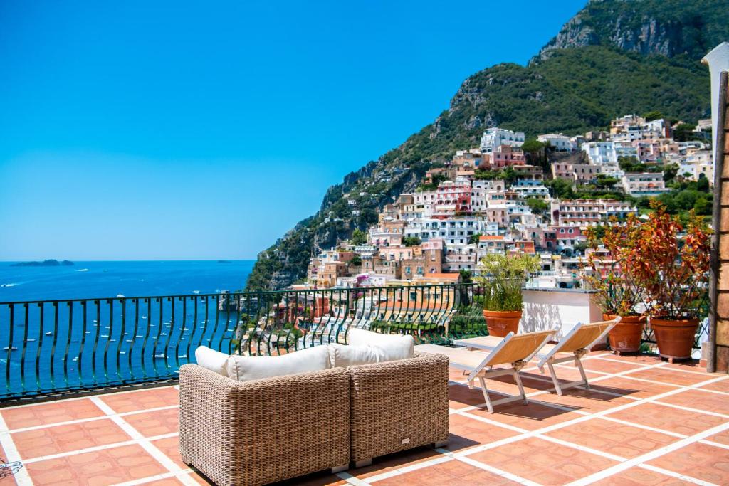 a balcony with chairs and a view of a city at Alcione Residence in Positano