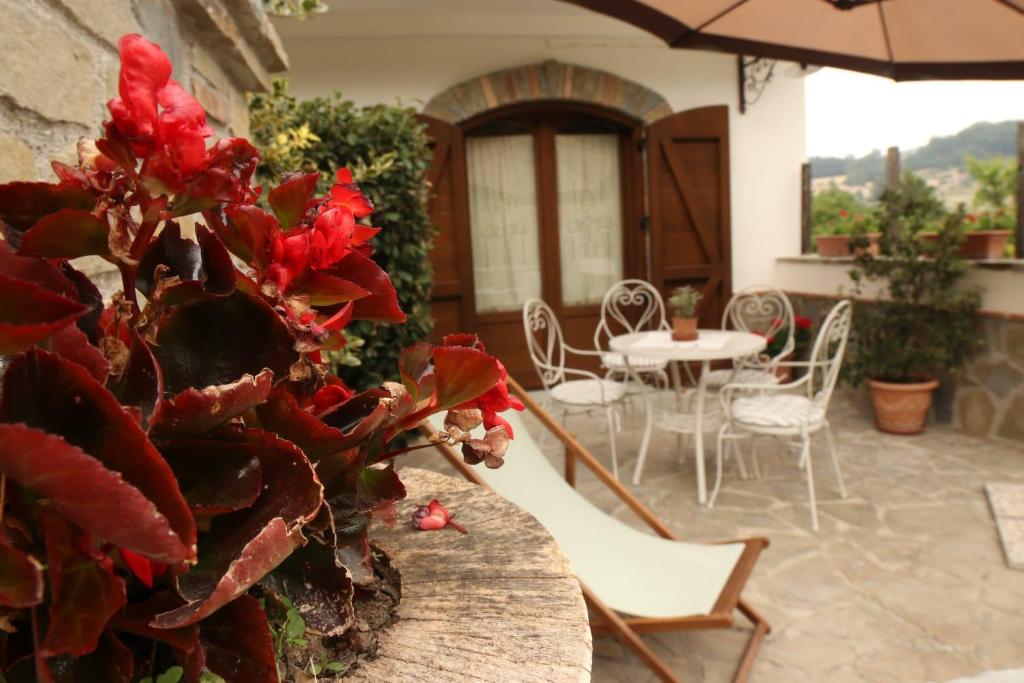 eine Terrasse mit einem Tisch, Stühlen und einem Sonnenschirm in der Unterkunft Villa Manca in San Severino Lucano