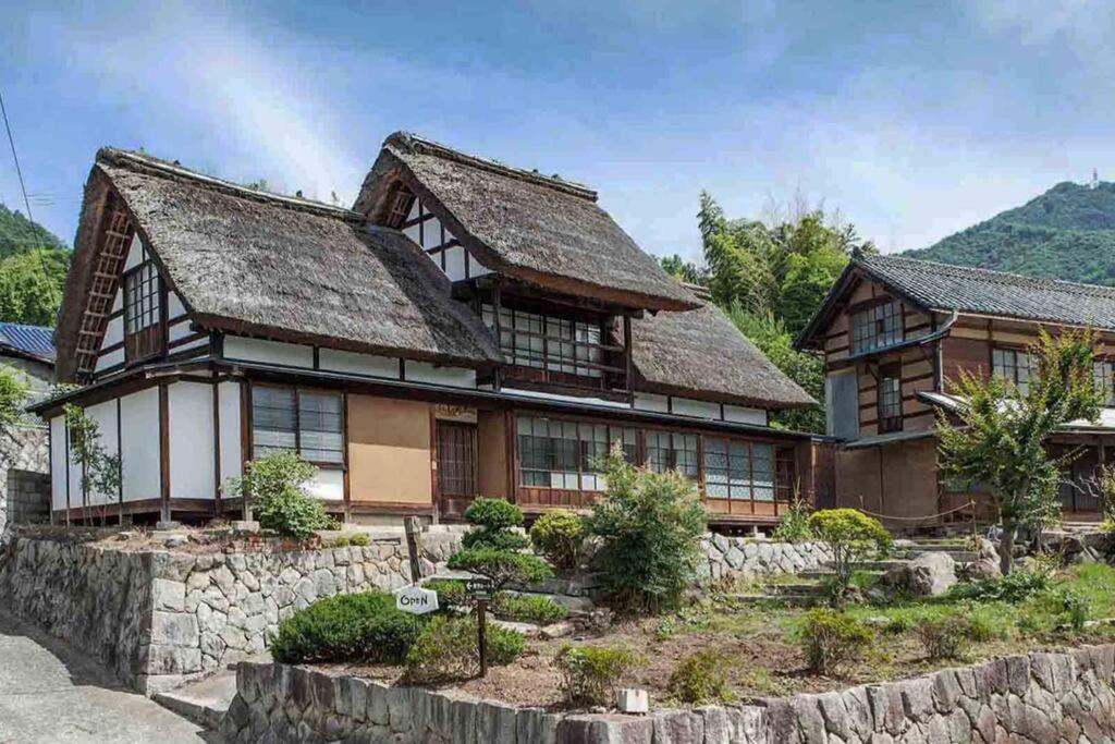 a large wooden house with a thatched roof at もしもしの家 in Koshu