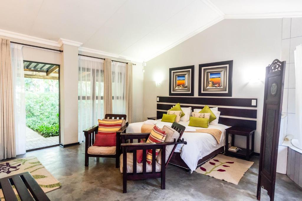 a bedroom with a large bed with colorful pillows at Winterton Country Lodge @ Rose Cottage in Winterton