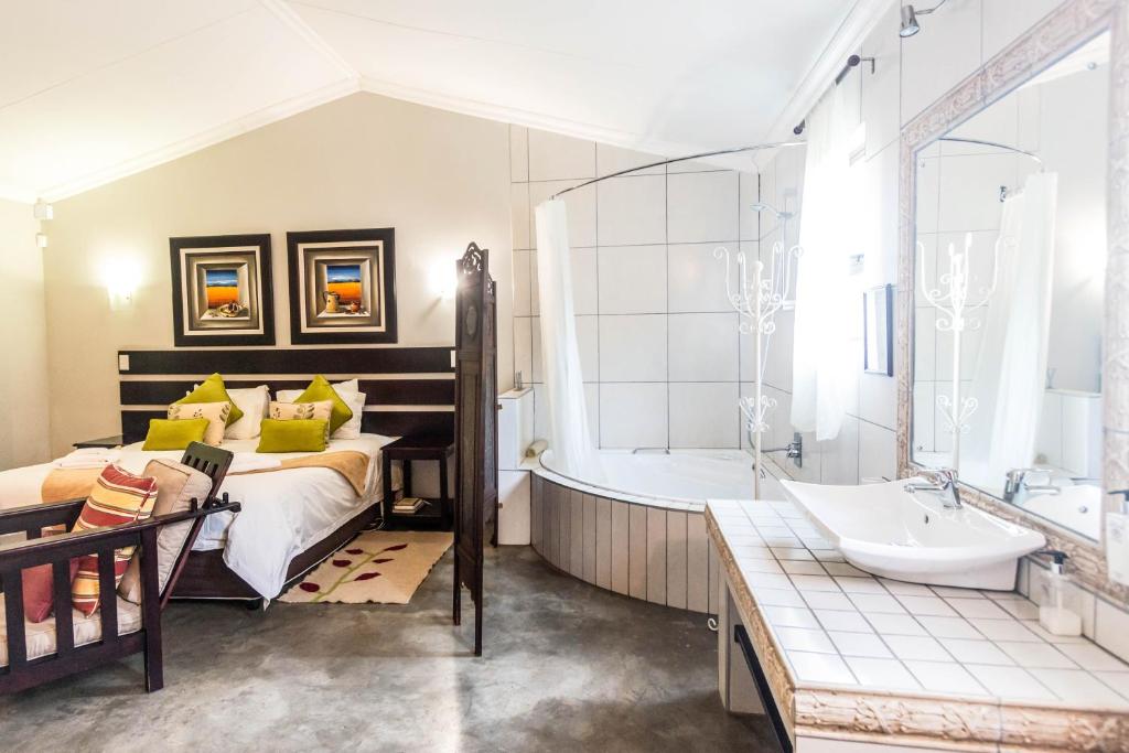 a bathroom with a bed and a tub and a sink at Winterton Country Lodge @ Rose Cottage in Winterton