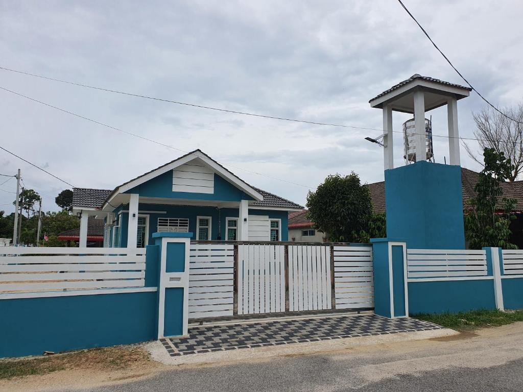 a blue house with a white fence and a gate at Casa De Rose KUBANG KERIAN in Kota Bharu