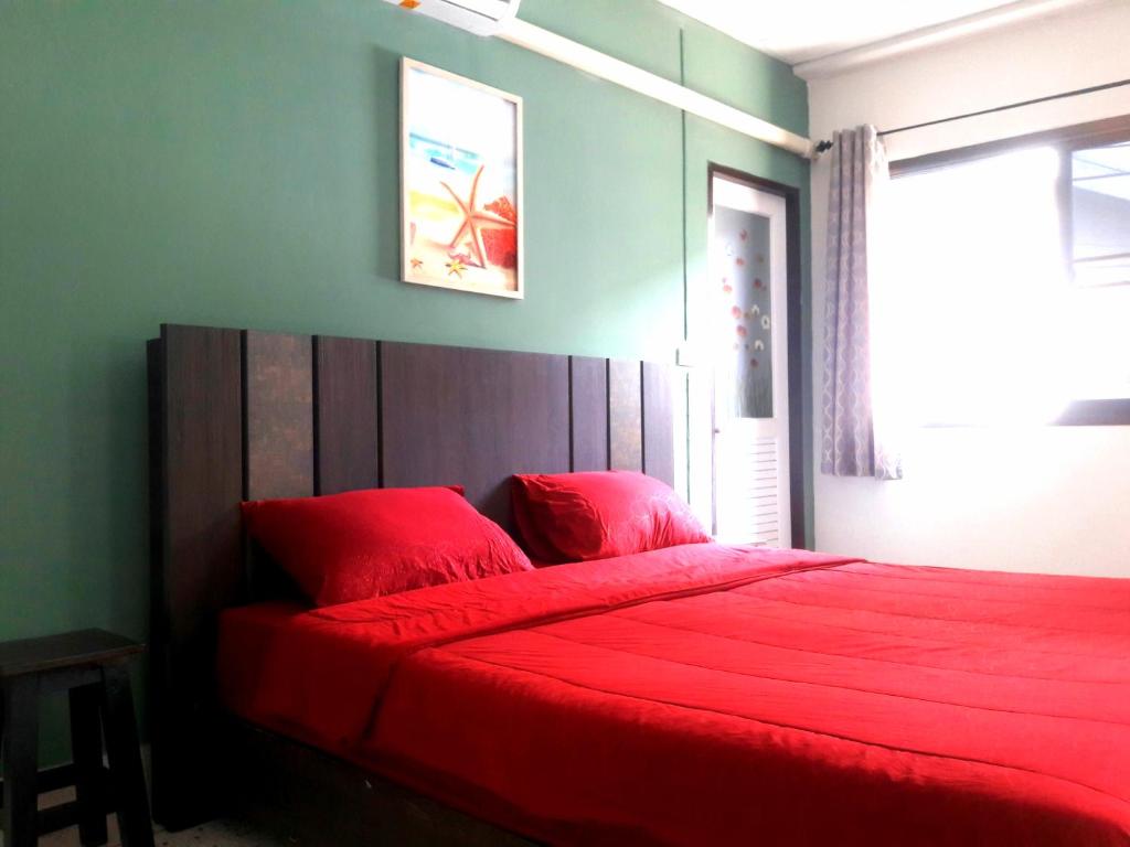 een slaapkamer met een rood bed en een rode deken bij U&D guest house in Bangkok