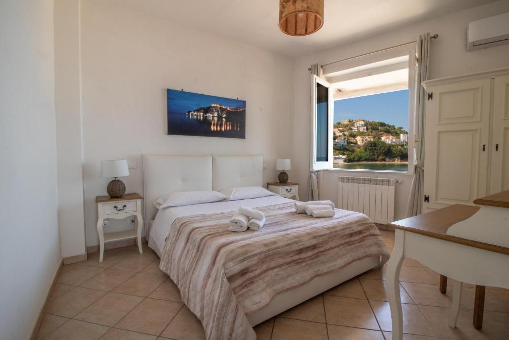 a bedroom with a bed and a desk and a window at 100 passi dal mare in Agropoli