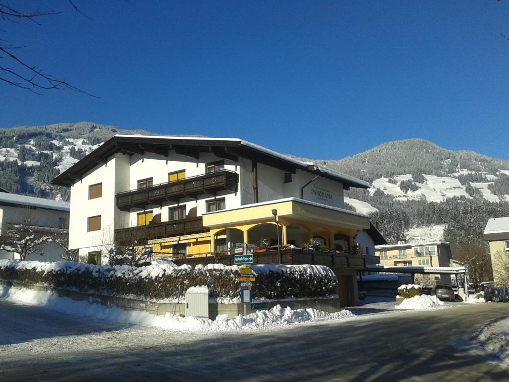 a large building on a street with snow on the ground at Apart Kofler's Panorama-Zillertal in Fügen