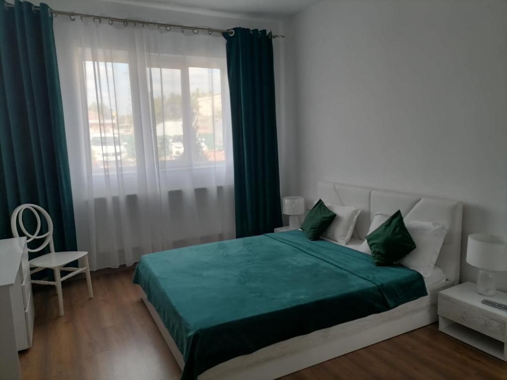 Un dormitorio con una cama verde y una ventana en Casa Regala EAR, en Craiova