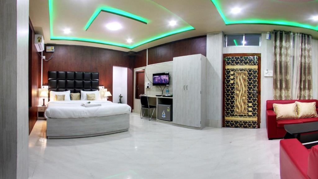 a hotel room with a bed and a tv at wings THE PRIDE in Jorhāt