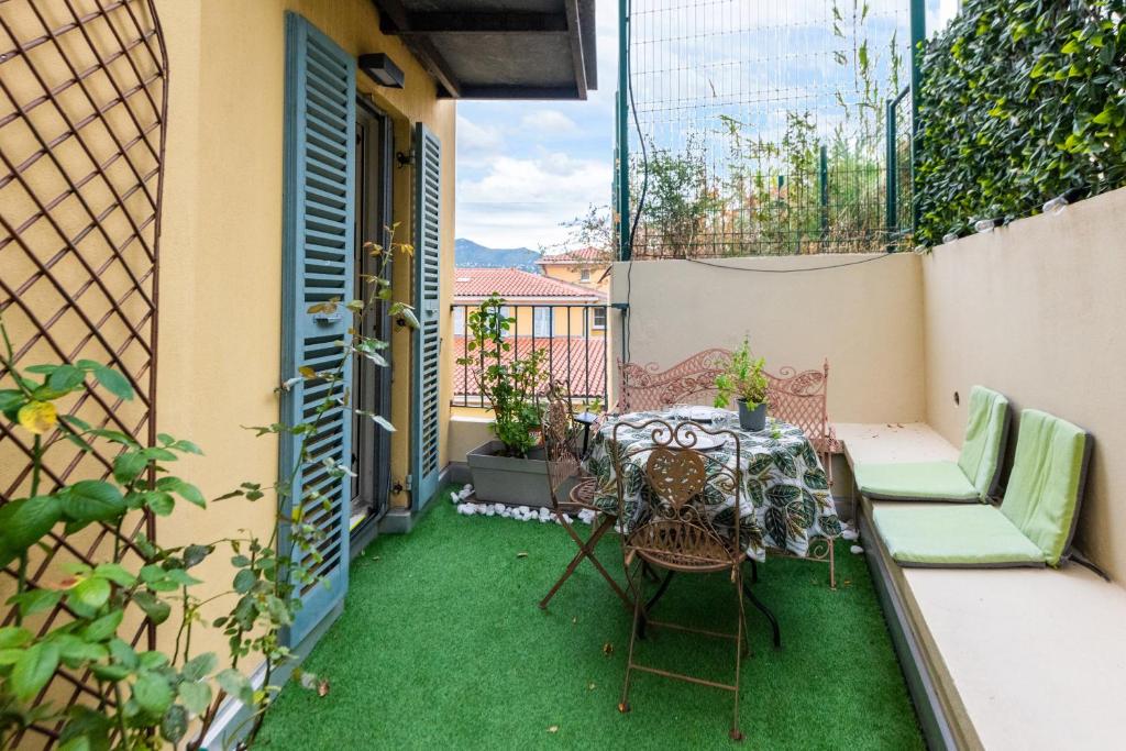 d'une terrasse avec de la pelouse verte, une table et des chaises. dans l'établissement La Providence, à Nice