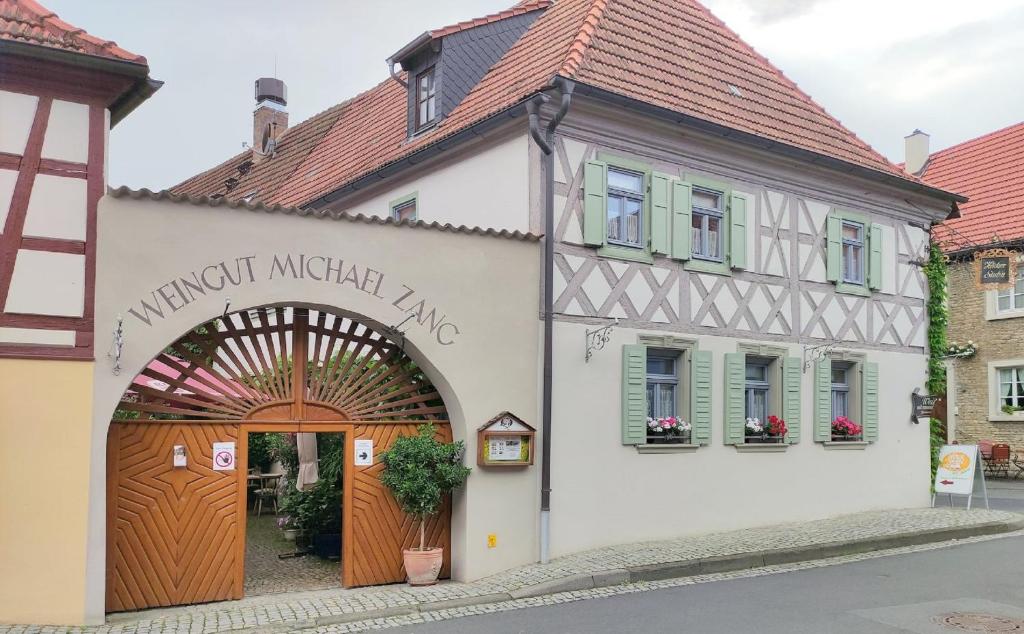 un edificio blanco con un arco delante de él en Ferienwohnung Häckerstub'n Zang, en Sommerach