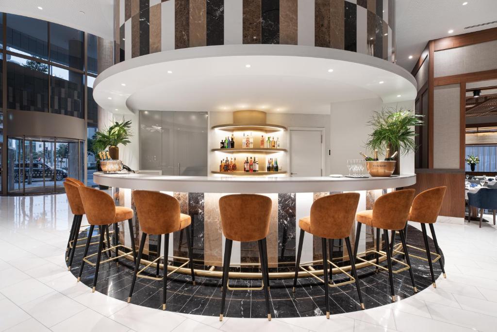 A rounded lobby bar offers a continuous counter with upholstered stools.