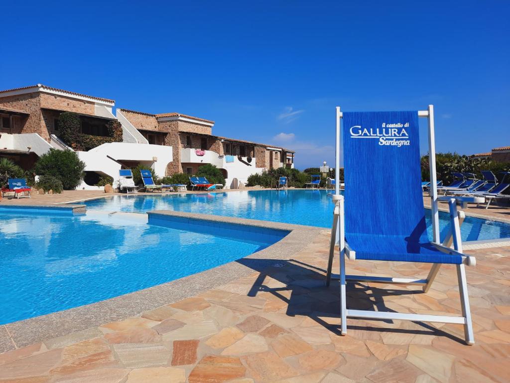 a blue chair sitting next to a swimming pool at Case Vacanza Castello di Gallura in Santa Teresa Gallura