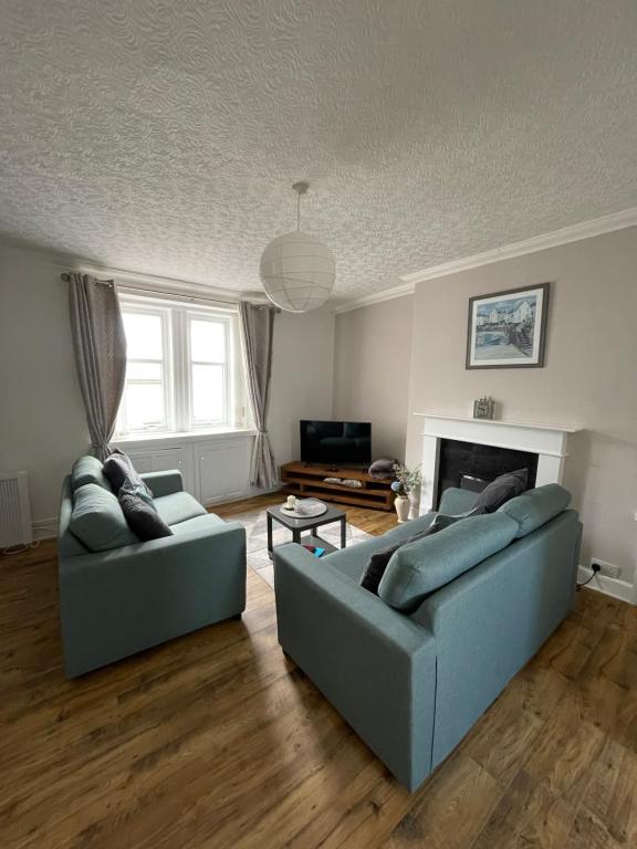 a living room with two couches and a fireplace at Albert Road Apartment in Eyemouth