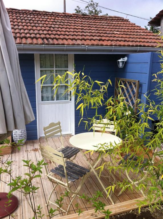 une maison bleue avec une table et des chaises sur une terrasse dans l'établissement Chambres d'hôtes Le Mont d'Anon, à Goviller