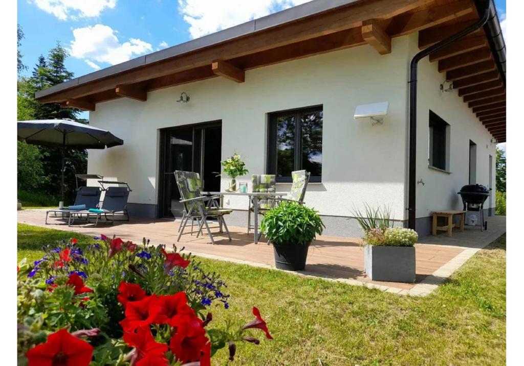 ein Haus mit einer Terrasse und Blumen im Hof in der Unterkunft Ferienhaus Angel in Weitra